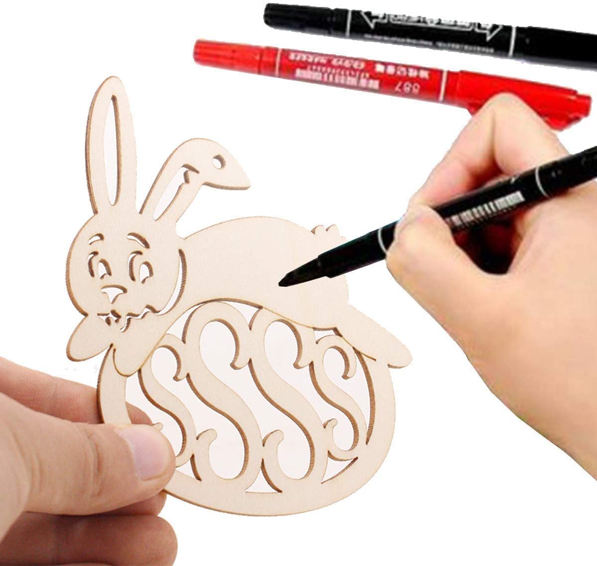 Wooden cutout with rabbit design and monogram, being marked with a pen.