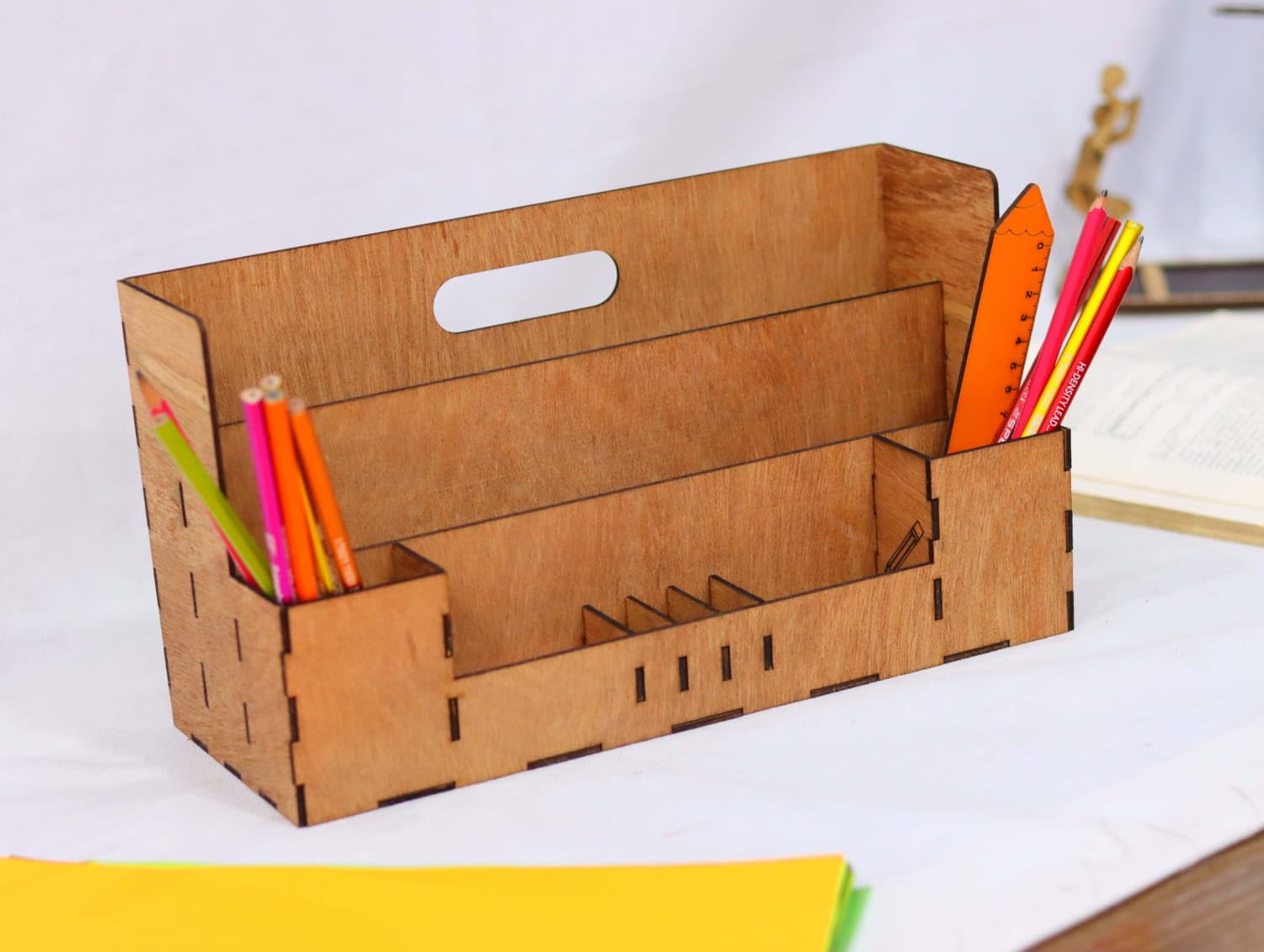 Cardboard desk organizer with stationery items on a white surface