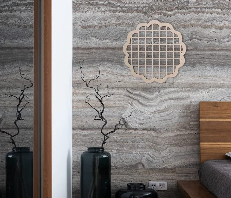 Decorative wall art with geometric pattern on a textured wall, flanked by dark vases and a wooden shelf.