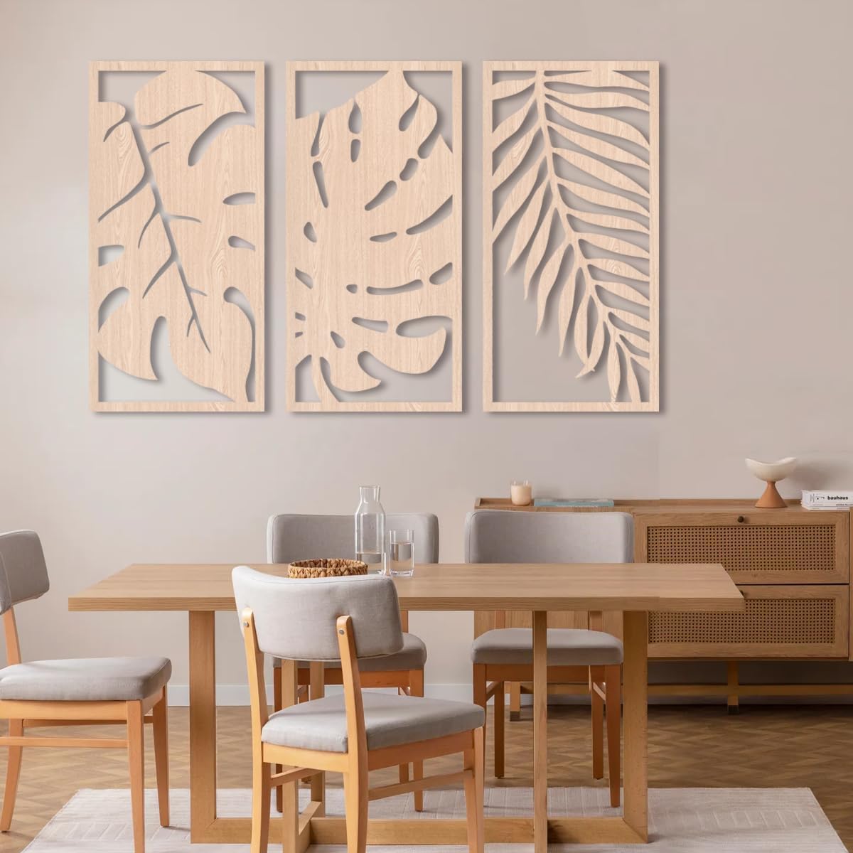 Dining room with wooden table and chairs, and decorative leaf wall art.