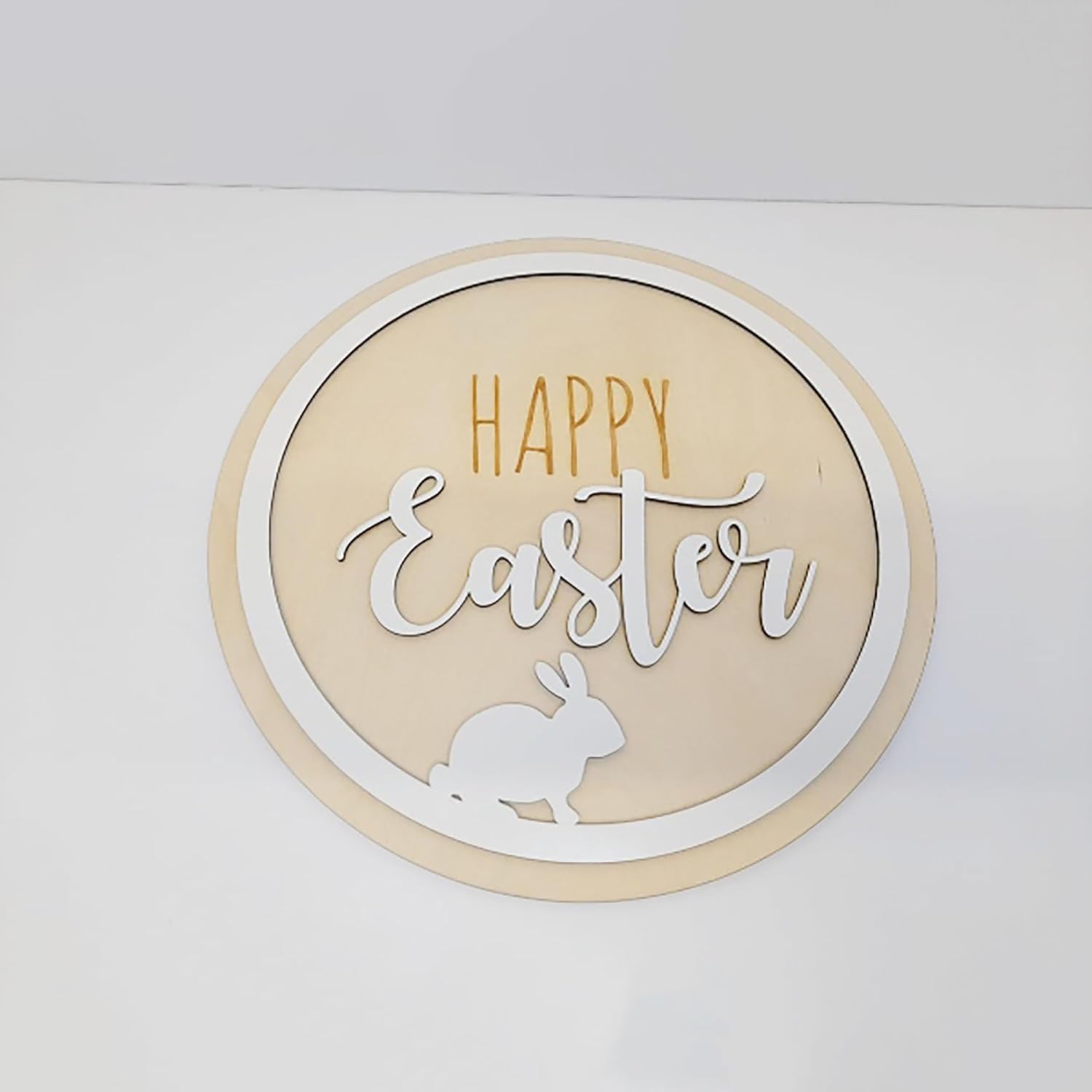 Round decorative sign with 'Happy Easter' text and a rabbit silhouette on a white background