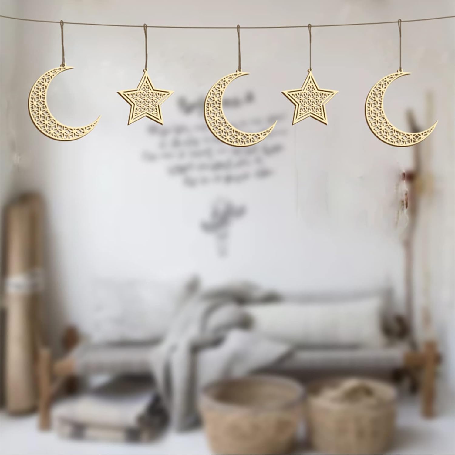 Decorative gold moon and star ornaments hanging against a blurred indoor background.