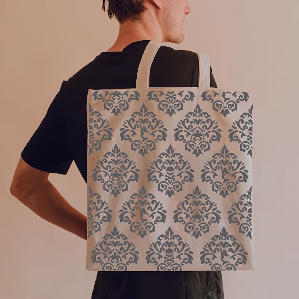 Person carrying a tote bag with a decorative pattern on a plain background