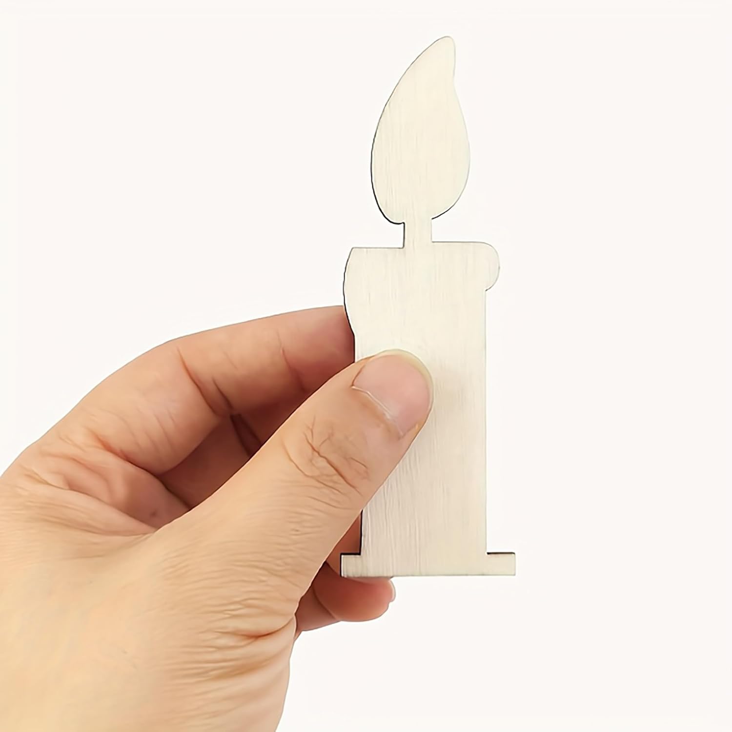 Hand holding a small white candle-shaped object against a white background