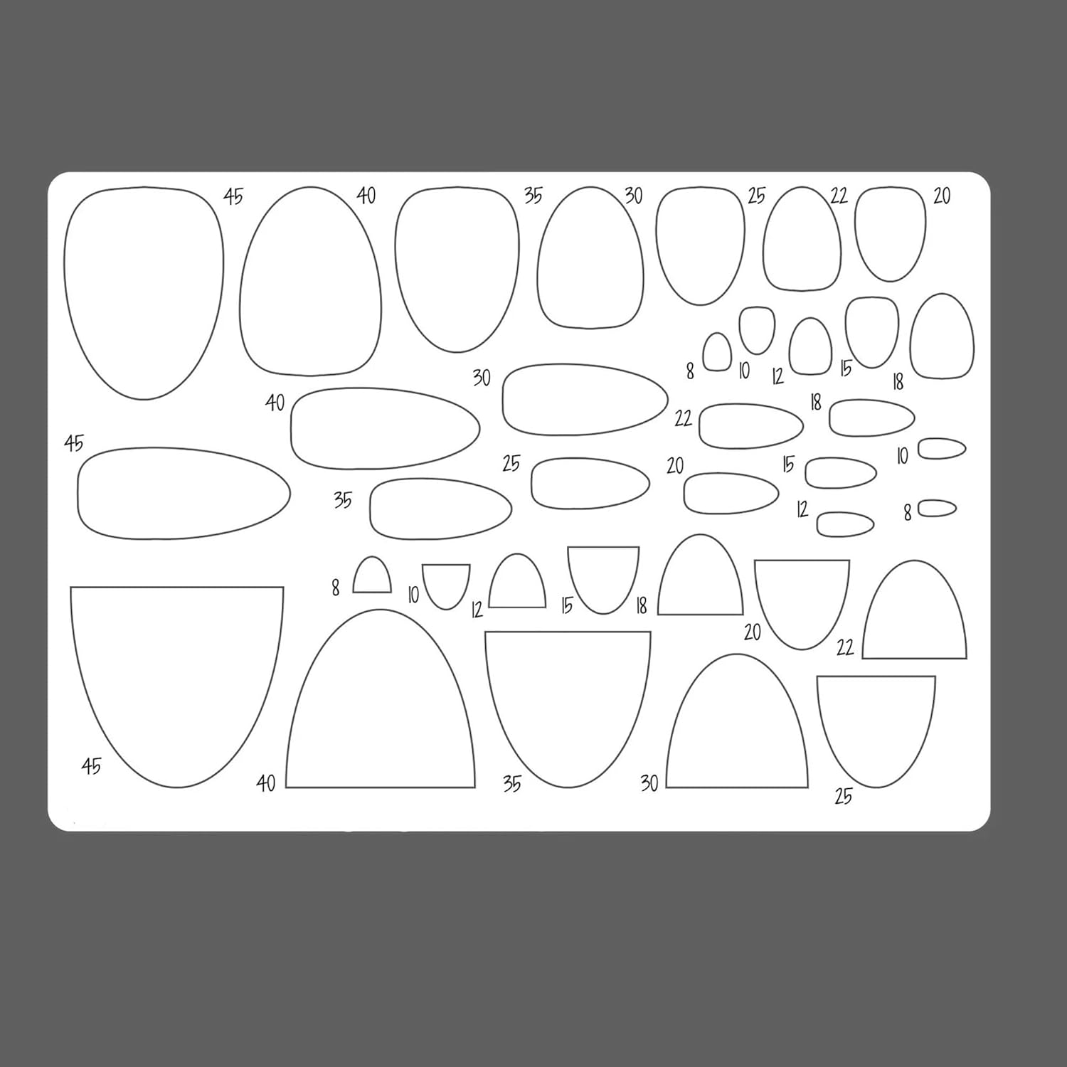 Sheet of oval and curved templates with measurements on a gray background