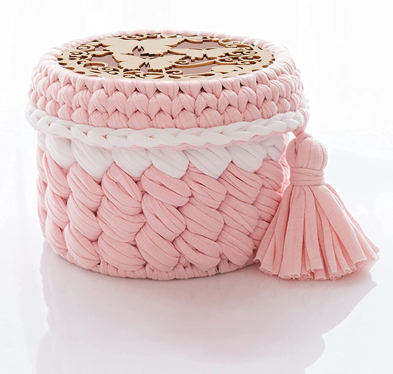 Pink woven box with a tassel on a white background