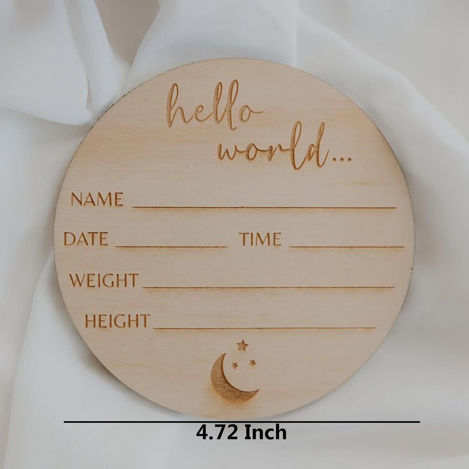 Wooden circular plaque with engraved text and moon design on a white fabric background