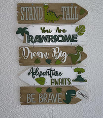 Decorative sign with motivational phrases and dinosaur illustrations on a white wall.