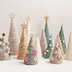 Decorative Christmas trees made of yarn with various decorations on a light background