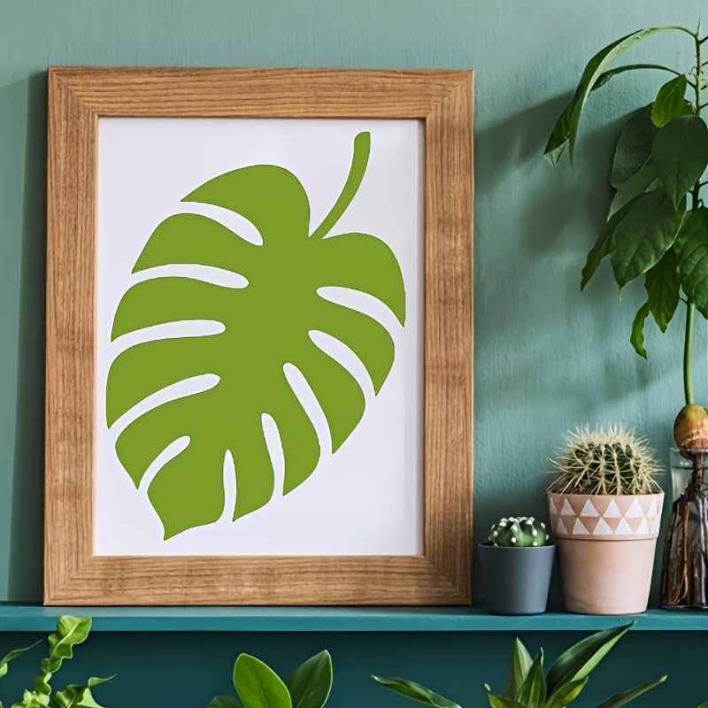 Framed print of a green leaf on a teal wall with potted plants.