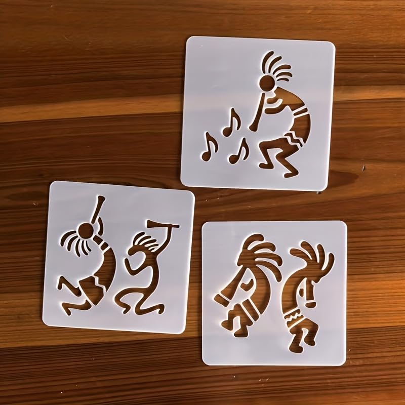 Three white stencils with brown Kokopelli designs on a wooden surface