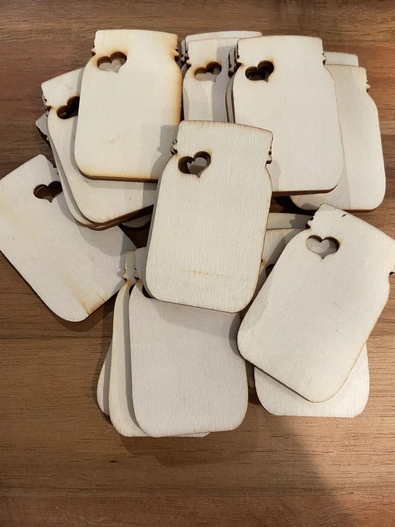 Stack of white paper tags with heart cutouts on a wooden surface
