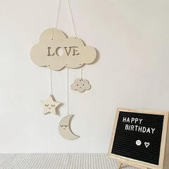 Decorative cloud with 'LOVE' and hanging stars, moon, and cloud on a light background.