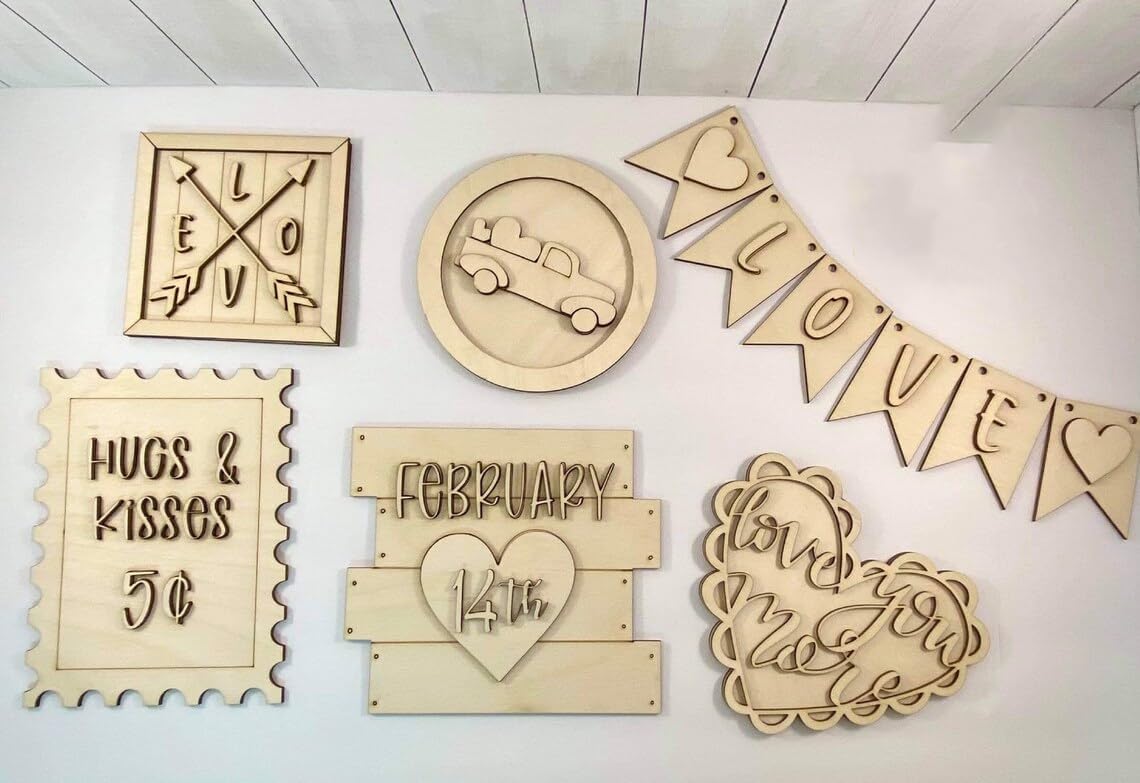 Collection of wooden decorative signs with various designs on a white surface.