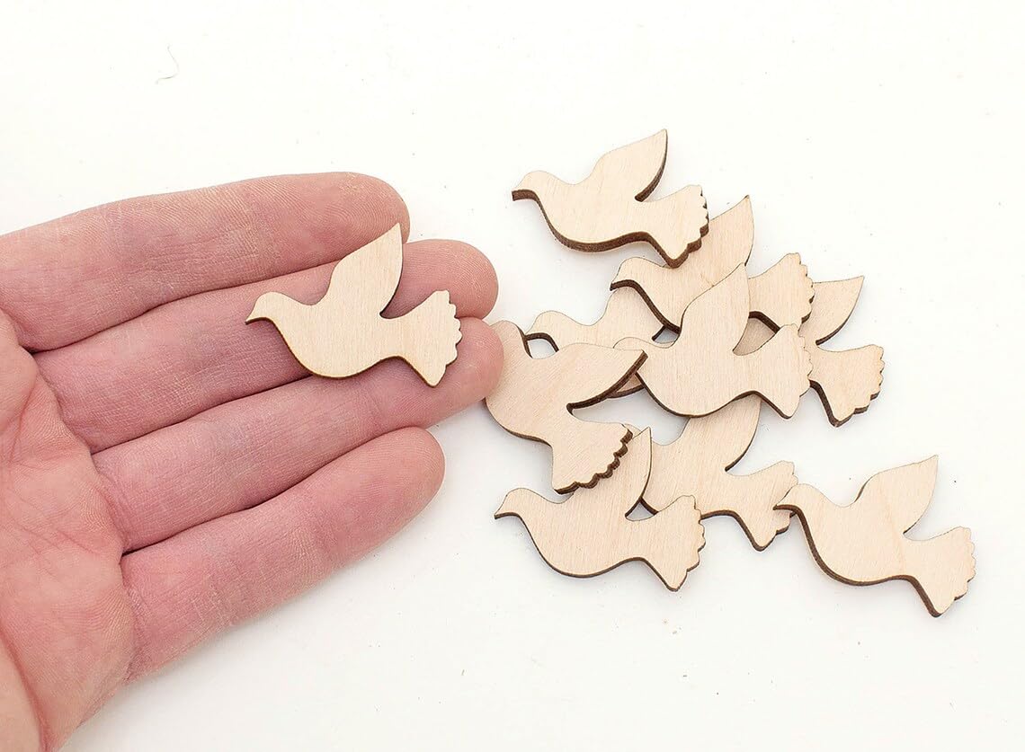 Wooden dove shapes on a white background with a hand holding one shape.