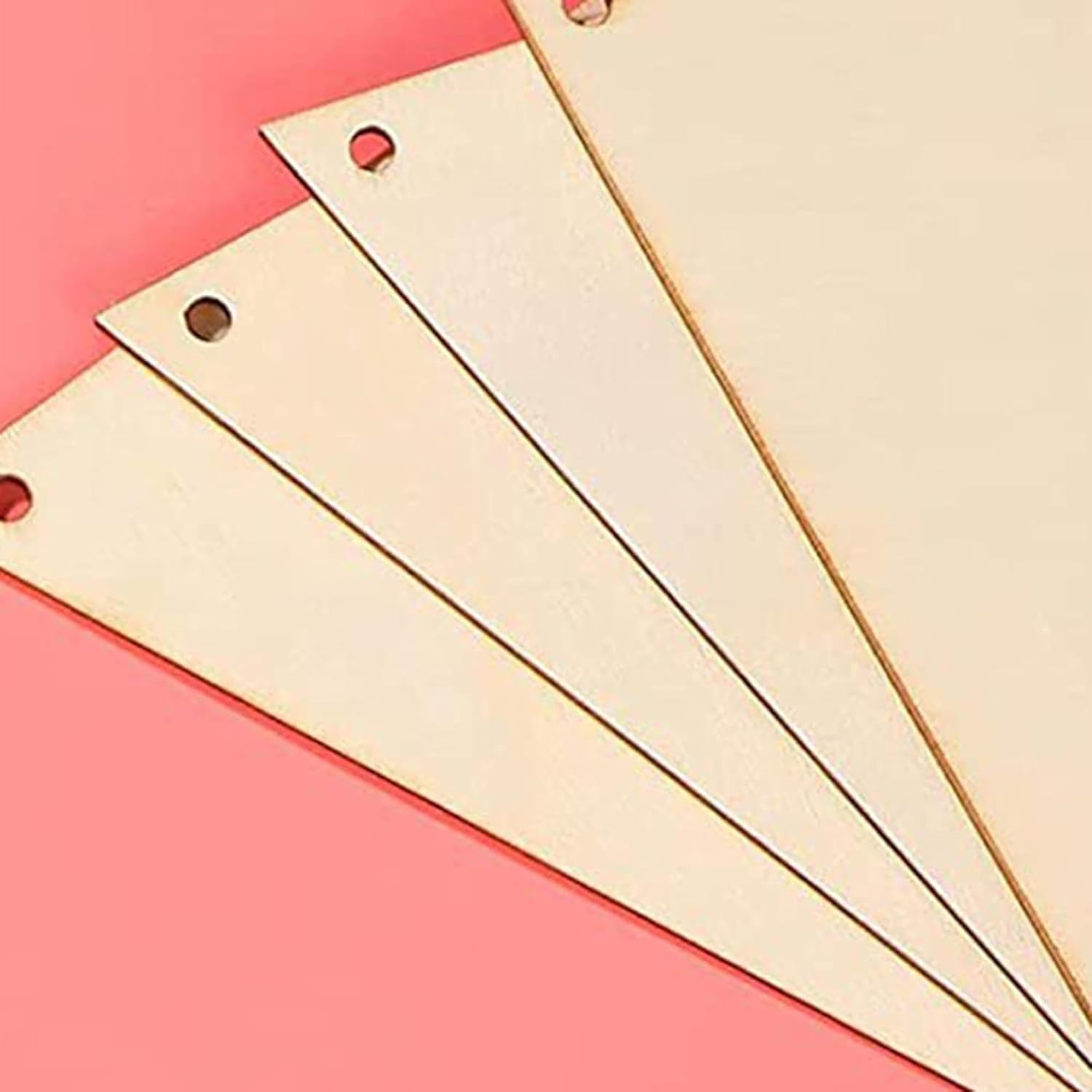 Three beige metal brackets on a pink background