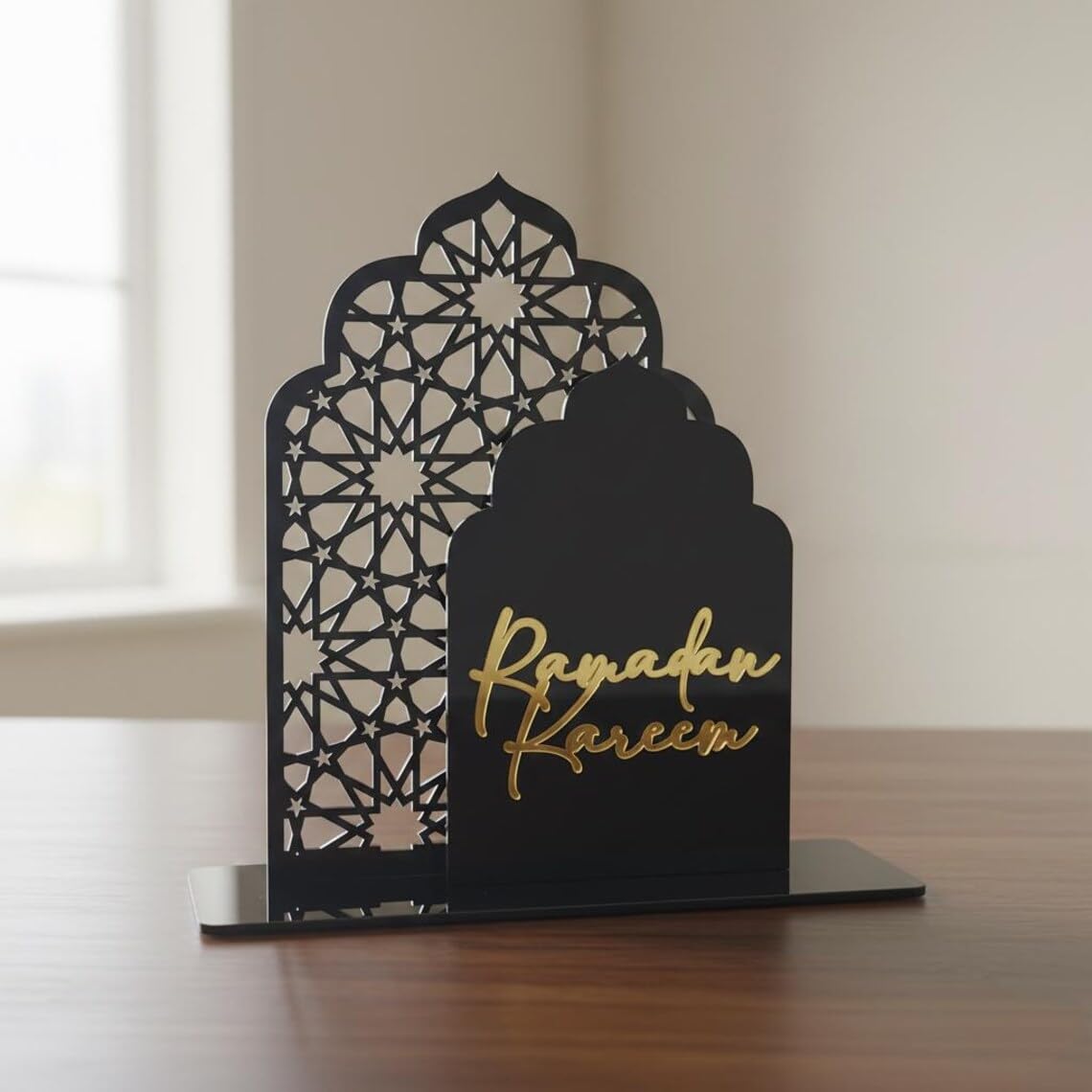 Decorative metal stand with 'Ramadan Kareem' text on a wooden surface.
