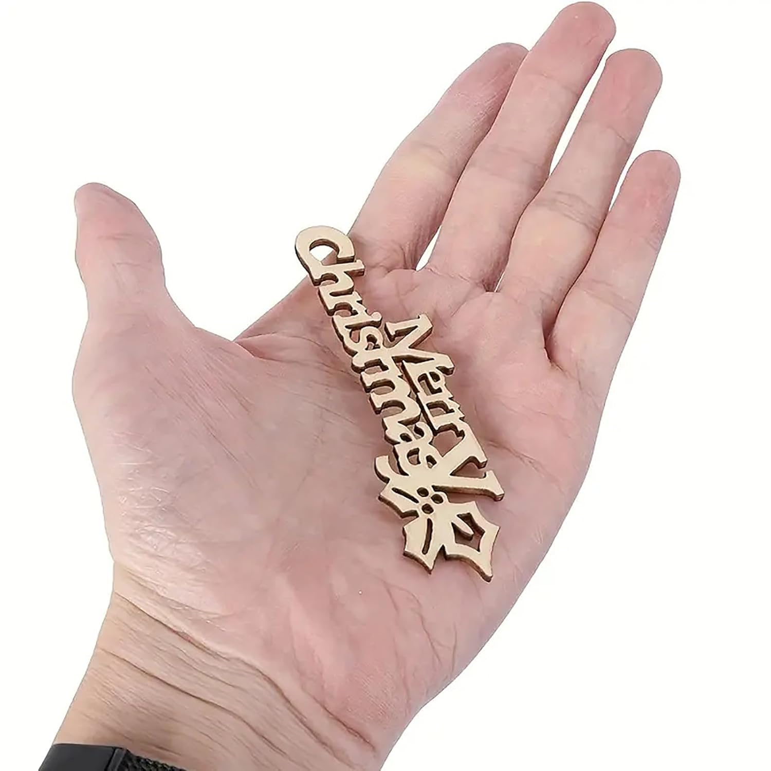 Wooden 'Merry Christmas' ornament held in a hand on a white background