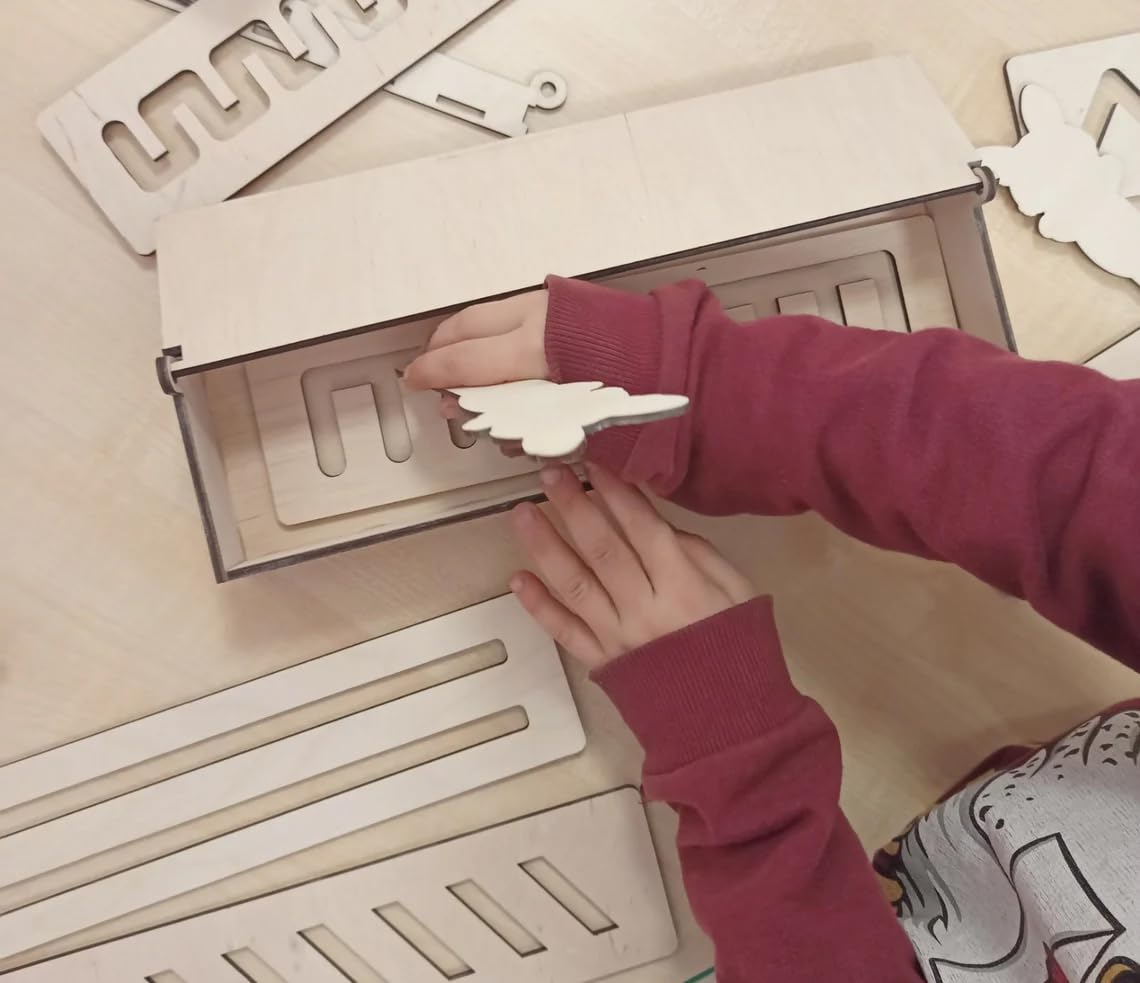 Person assembling wooden letters on a beige surface