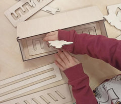 Person assembling wooden letters on a beige surface