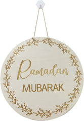 Round wooden sign with 'Ramadan Mubarak' in gold text on a white background