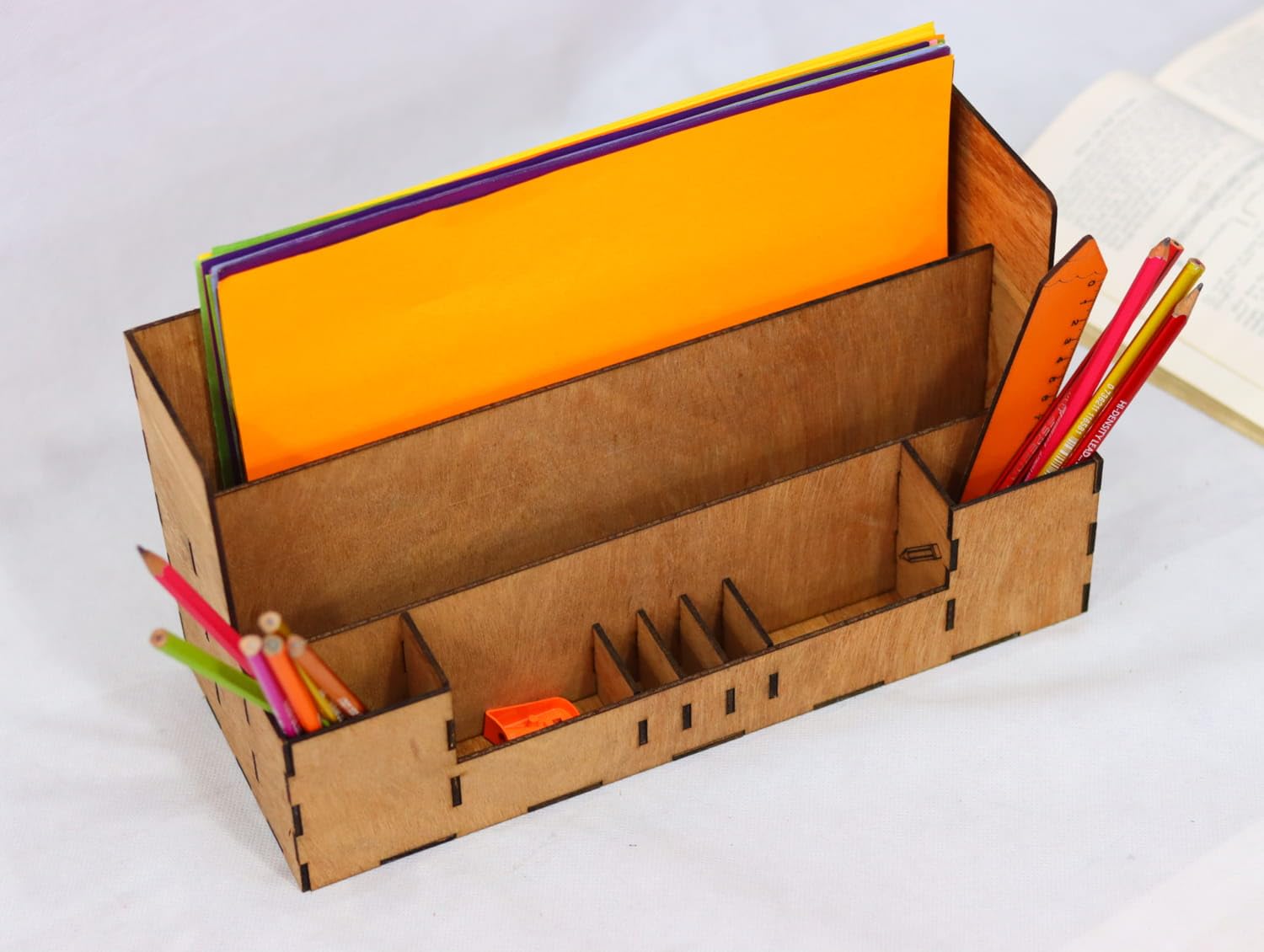Cardboard desk organizer with stationery items on a white background