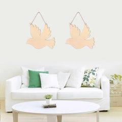 Two wooden dove decorations hanging above a white sofa with green and patterned cushions.