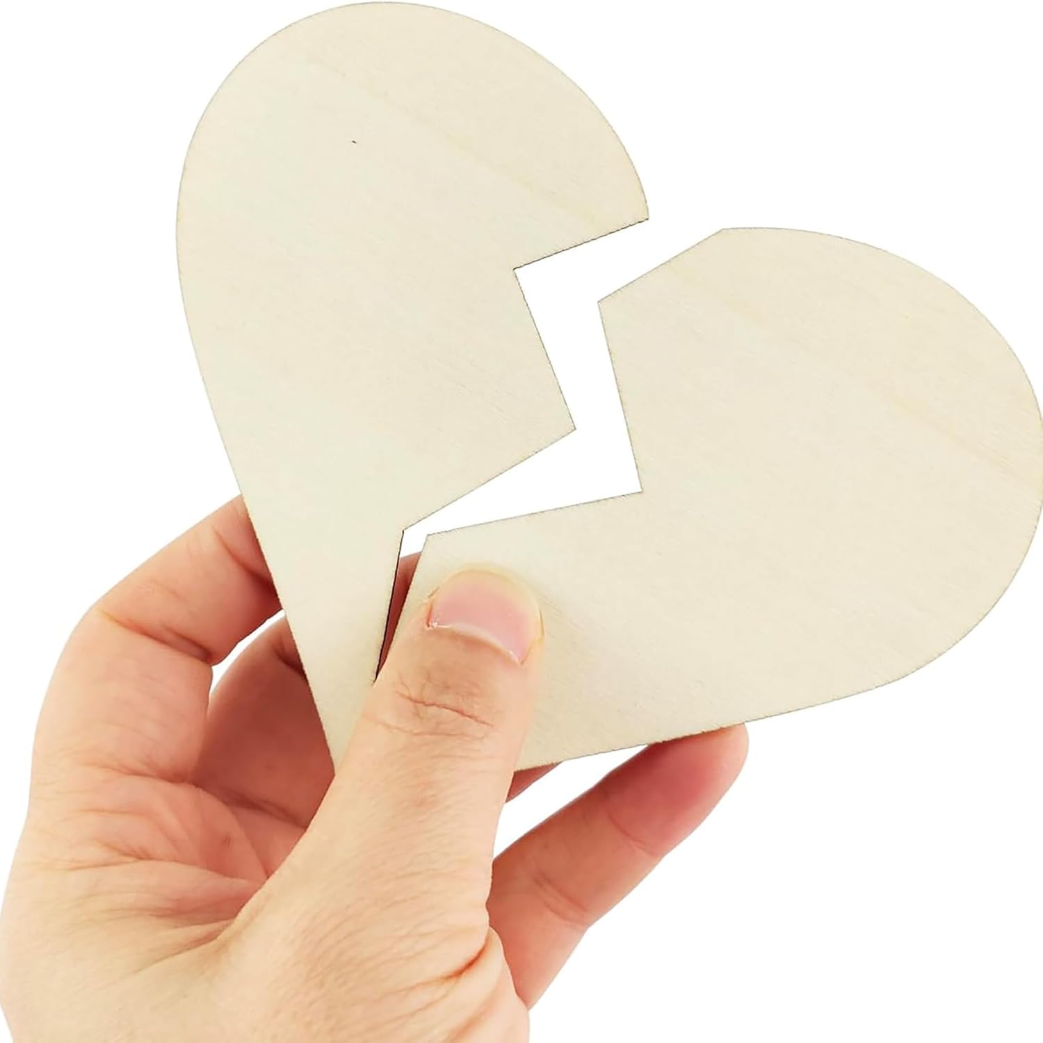 Hand holding a broken heart-shaped object on a white background