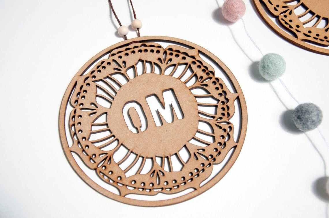 Decorative wooden pendant with 'OM' engraving on a white background