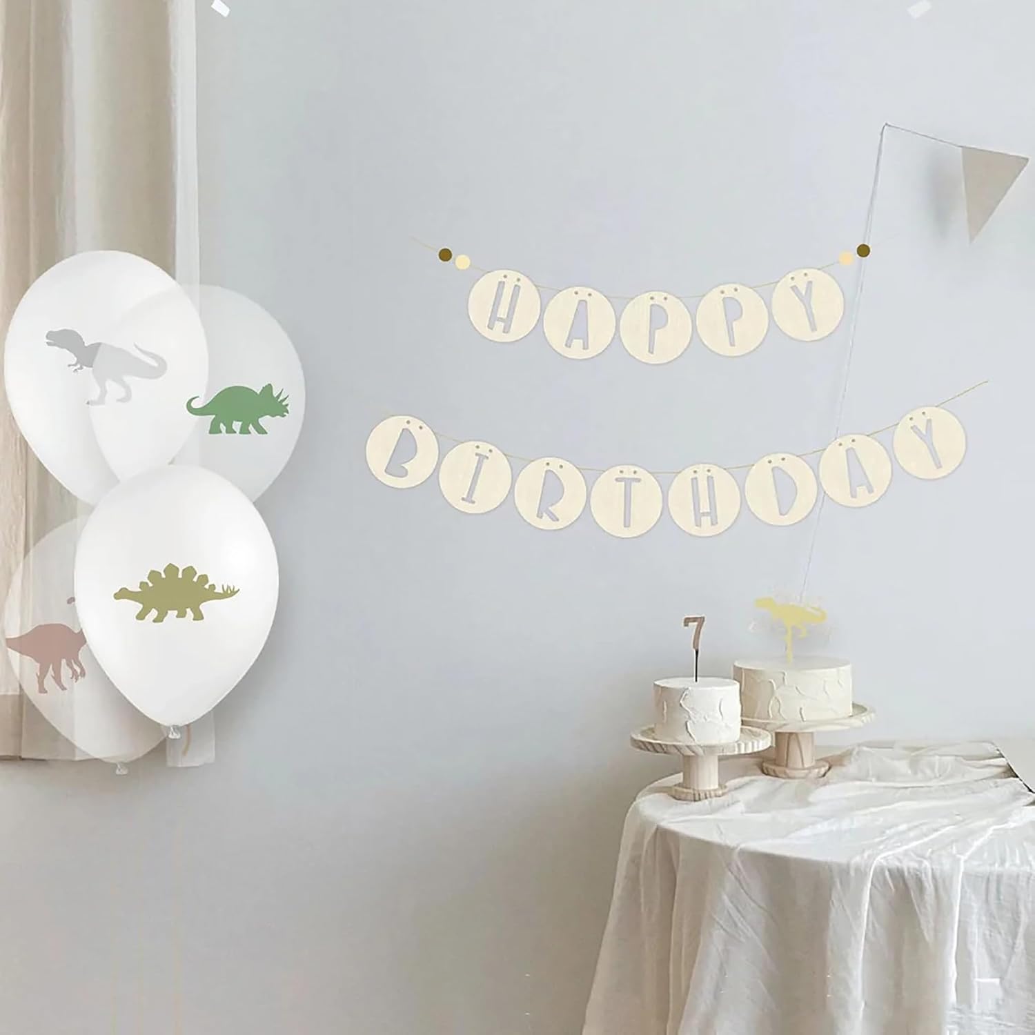 Dinosaur-themed birthday party setup with balloons and 'Happy Birthday' banner.