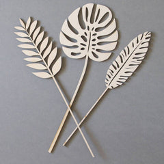 Three cut-out leaf shapes on sticks against a gray background