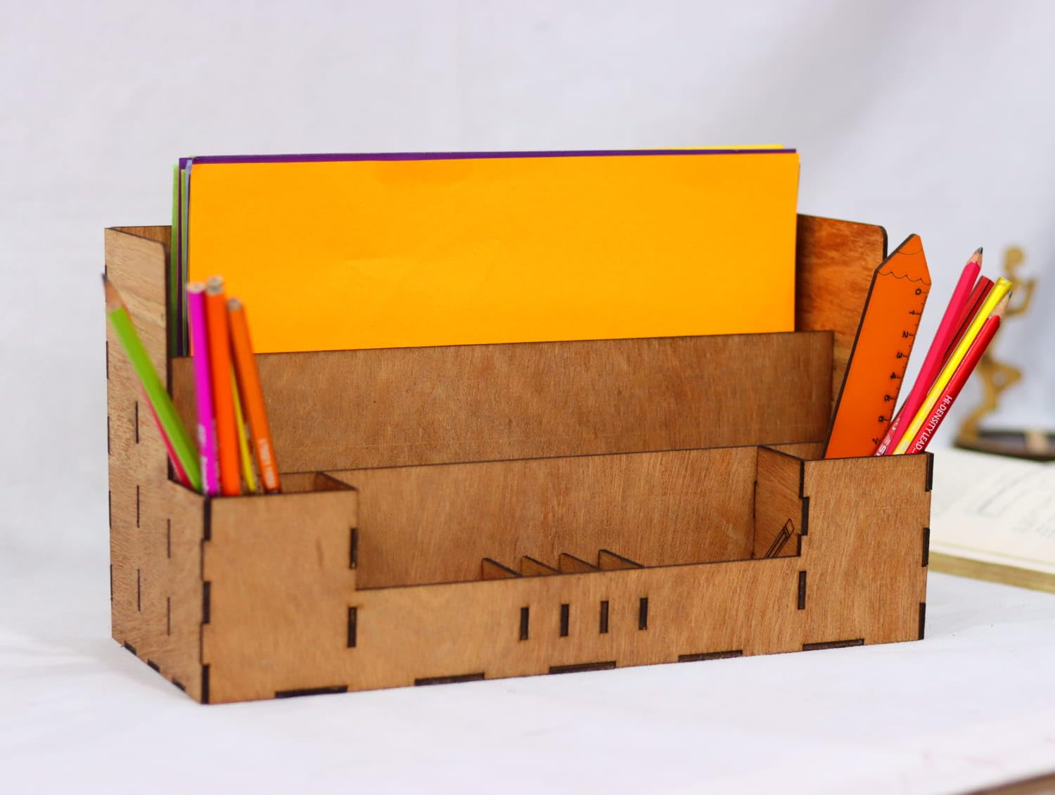Cardboard desk organizer with stationery items on a white background