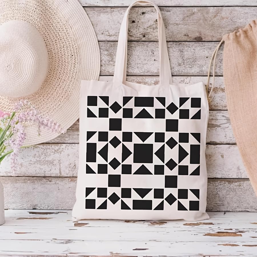 Tote bag with black geometric pattern on a wooden surface with a hat and flowers.