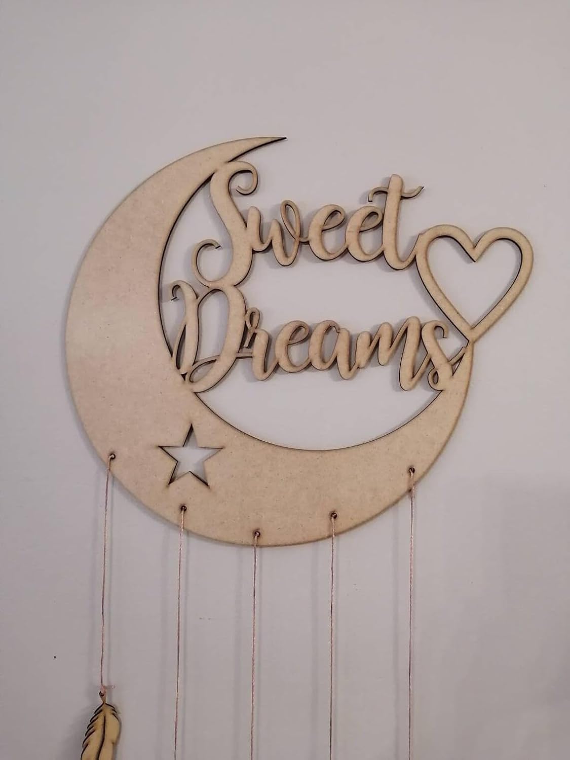 Wooden wall decor with 'Sweet Dreams' text on a crescent moon shape.