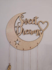 Wooden wall decor with 'Sweet Dreams' text on a crescent moon shape.