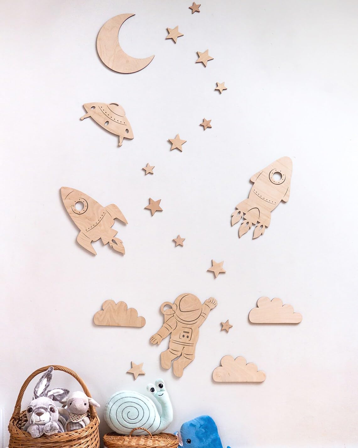 Wooden wall decor pieces including rockets, stars, and an astronaut on a light background.