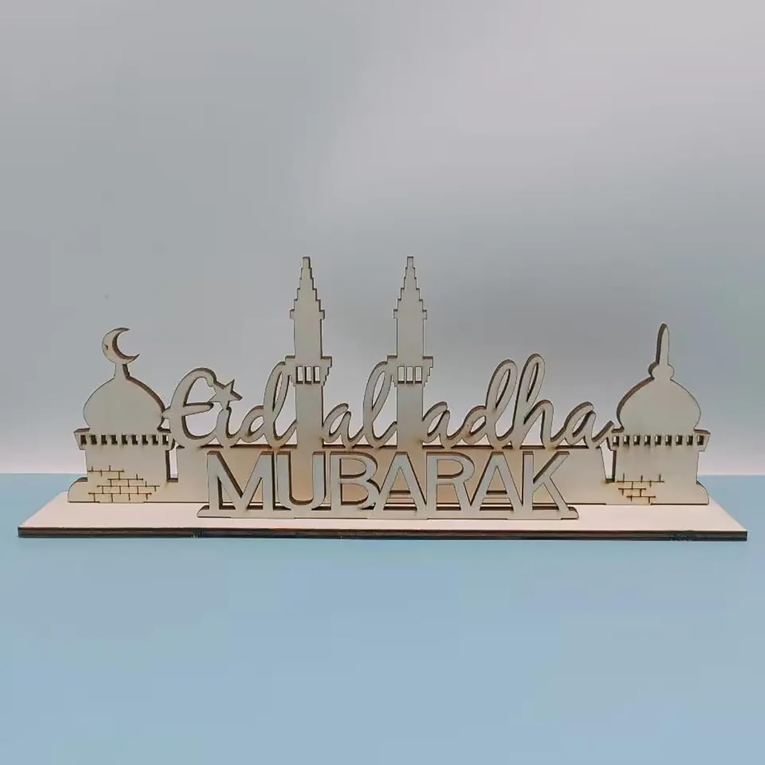 Decorative sign with 'Eid ul Adha Mubarak' text on a plain background