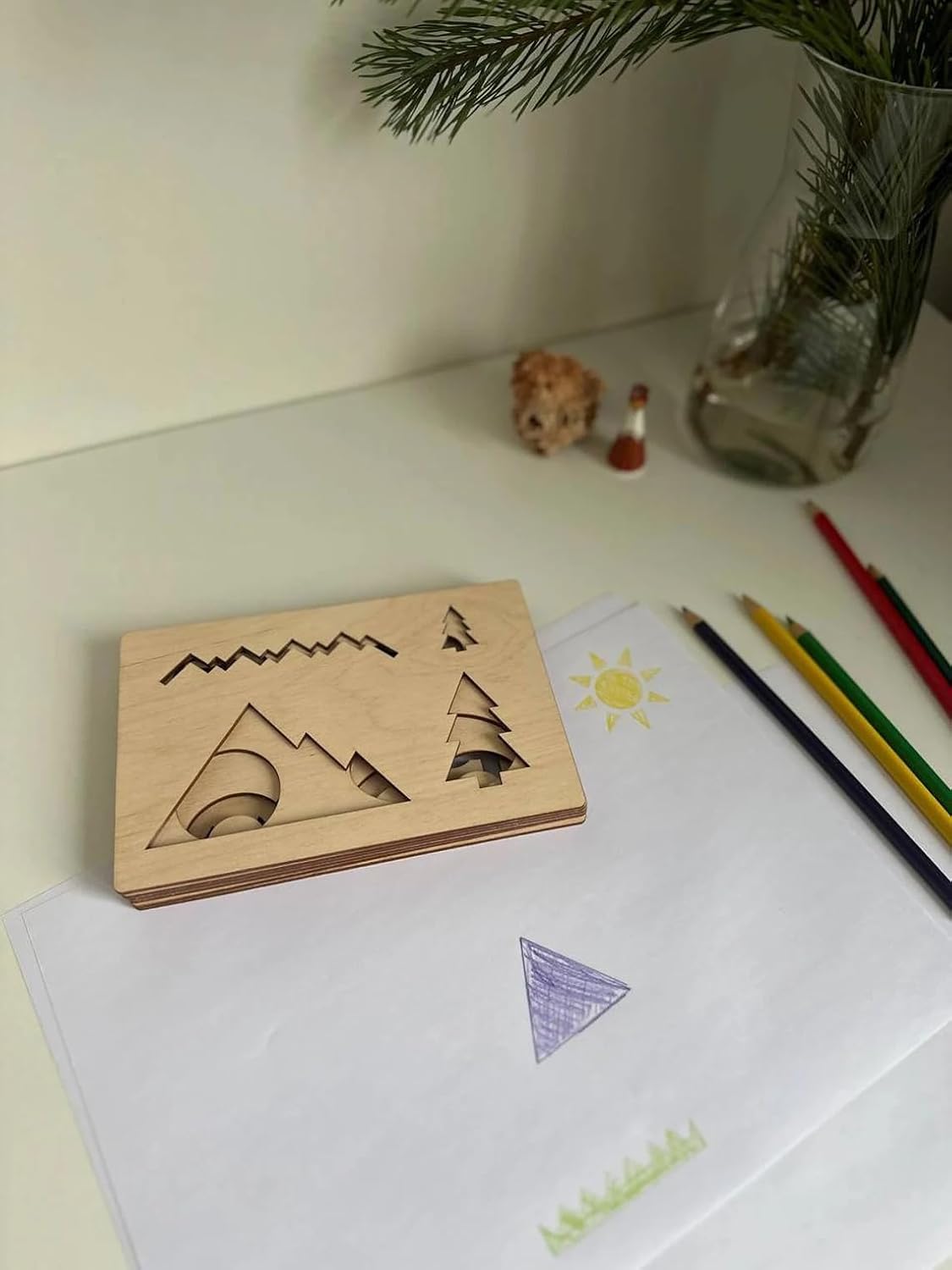 Wooden stamp with mountain design on a desk with stationery items