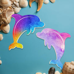 Colorful dolphin shapes on a blue background with seashells around.