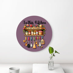 Decorative wall plate with kitchen-themed design and text 'In this kitchen, we make messes & memories' on a purple background.
