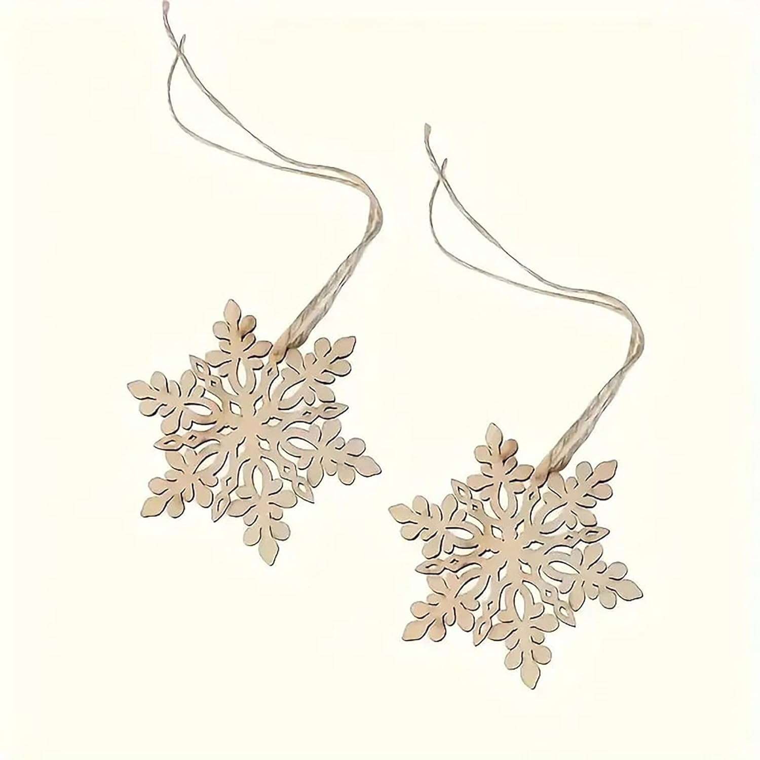 Two wooden snowflake ornaments on strings against a white background
