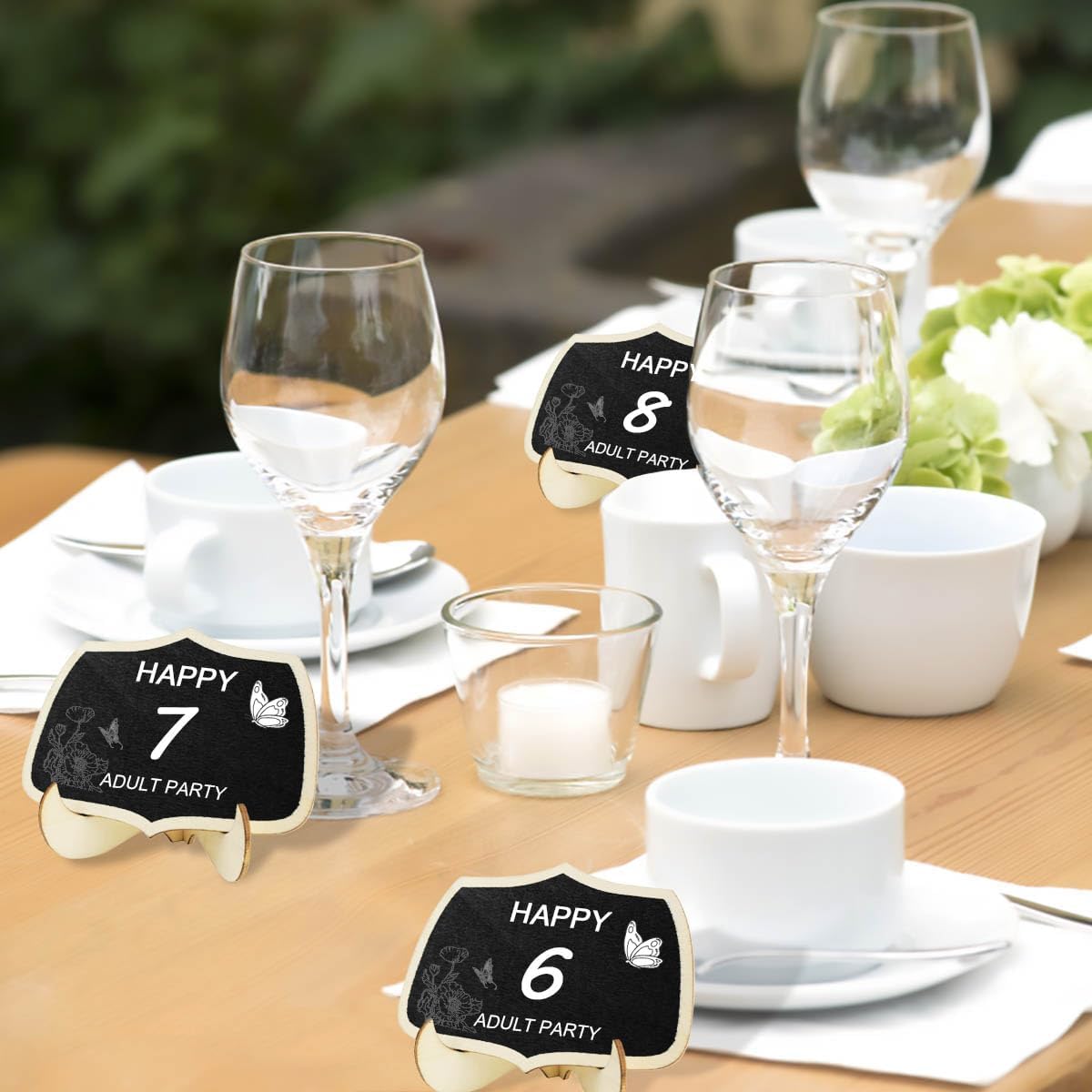 Table setting with wine glasses and decorative signs on a wooden table.