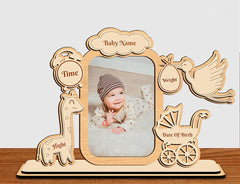 Wooden photo frame with engraved baby details on a wooden surface.