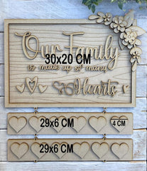 Wooden decorative sign with 'Our Family is made up of many Hearts' text and heart shapes, on a wooden background.