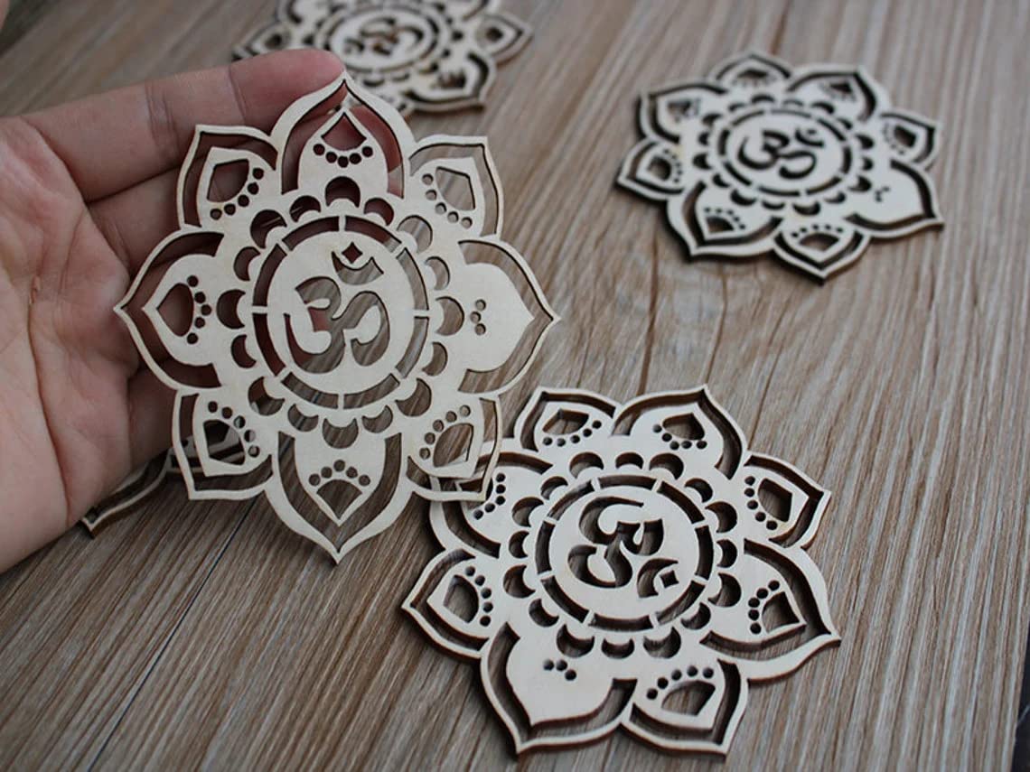 Decorative wooden pieces with intricate designs and 'Om' symbol on a wooden surface.