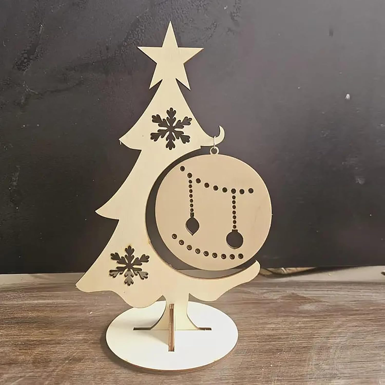 Wooden Christmas tree decoration with star and snowflakes on a dark background