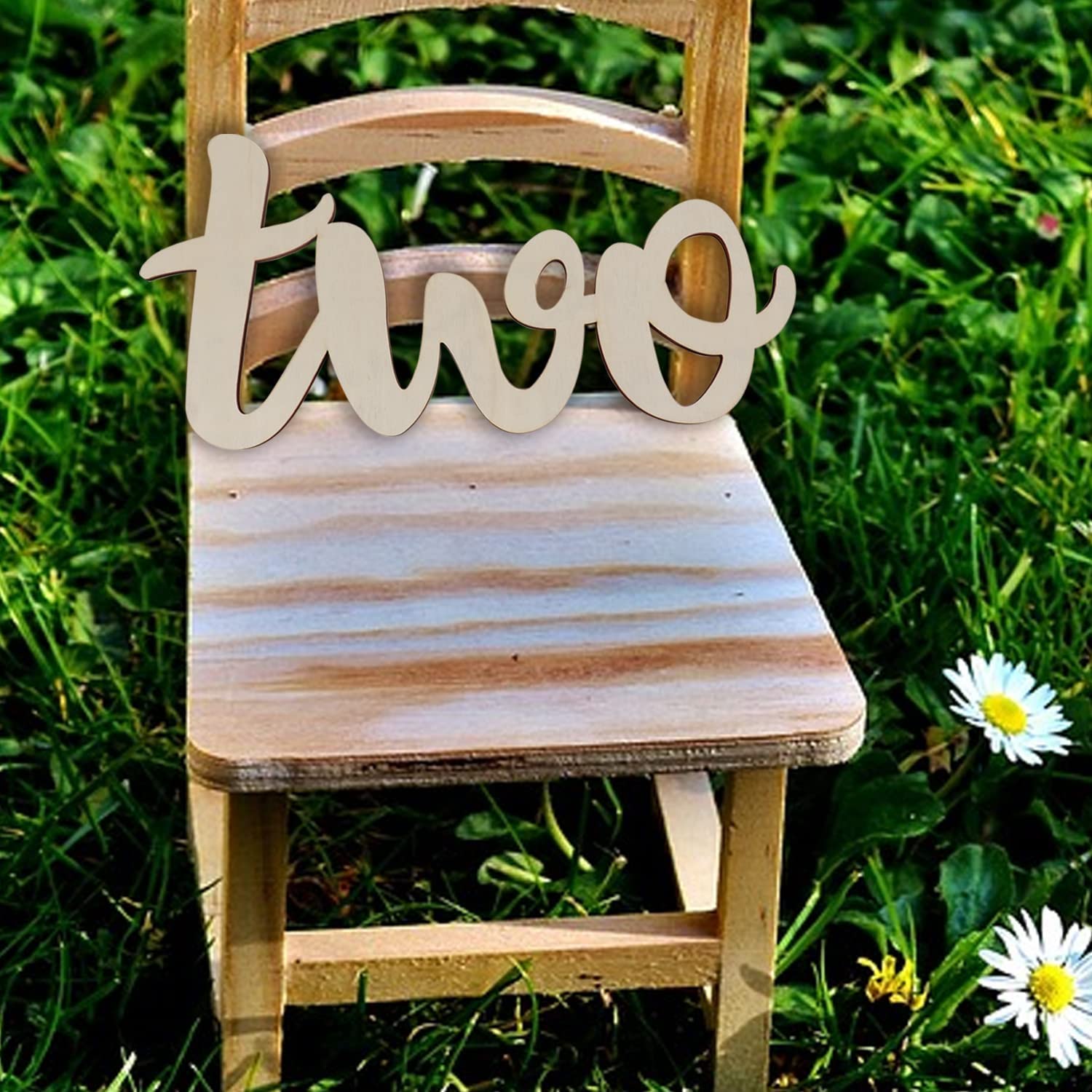 Wooden chair with 'two' sign on grass