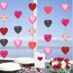 Valentine's Day decorations with heart-shaped balloons and a card on a table with flowers and plates.