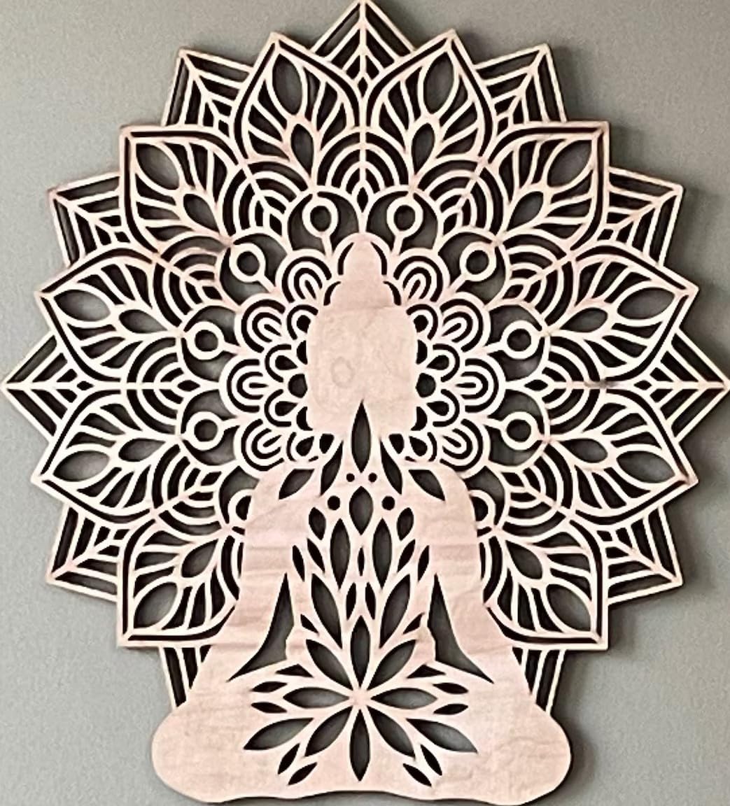 Decorative wall art with a mandala design featuring a silhouette of a person in a meditative pose on a gray background.