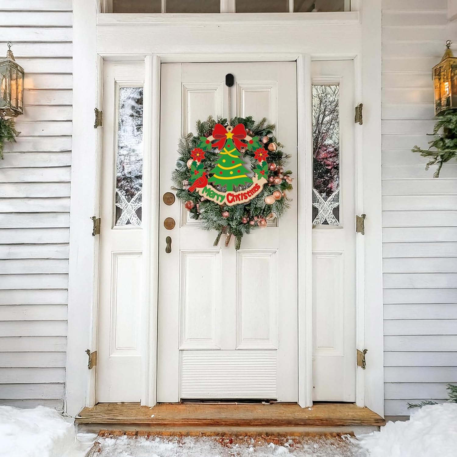 White door with a Christmas wreath decorated with a tree and red bows, surrounded by snow.